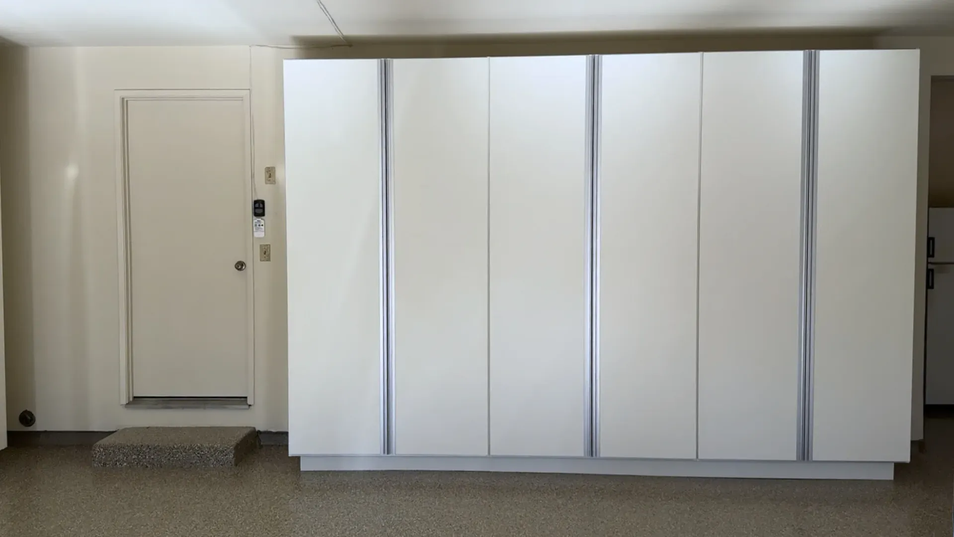 The same garage after installation, with cabinets along the wall and a clear floor.