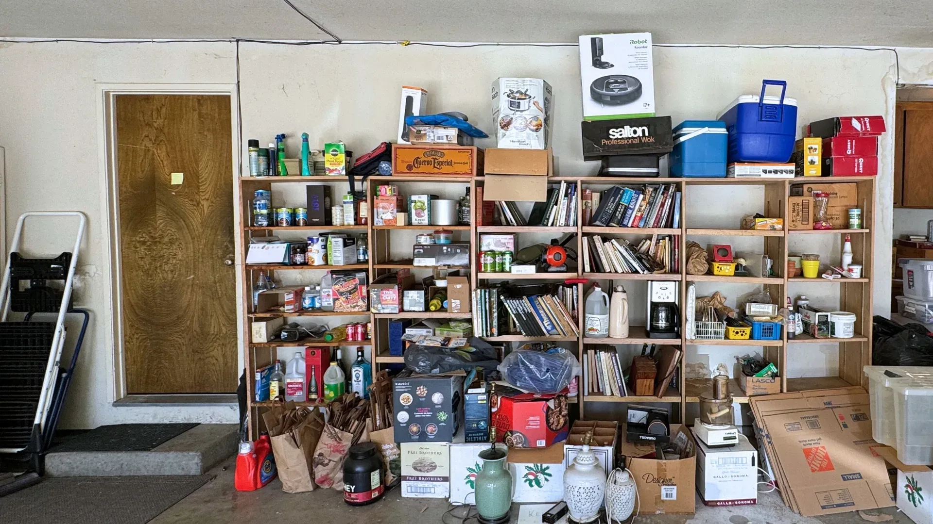 The same garage before installation, with bins and gear across the floor.