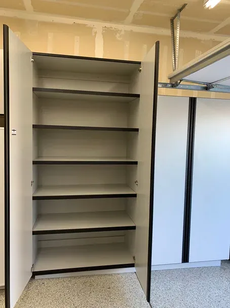 A full-height cabinet with both doors open, the lower shelves spaced wide for tall items.