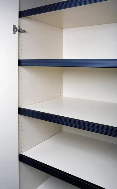 Three shelves inside a cabinet, each with dark metal edge reinforcement, with rows of shelf-pin holes for changing the spacing.