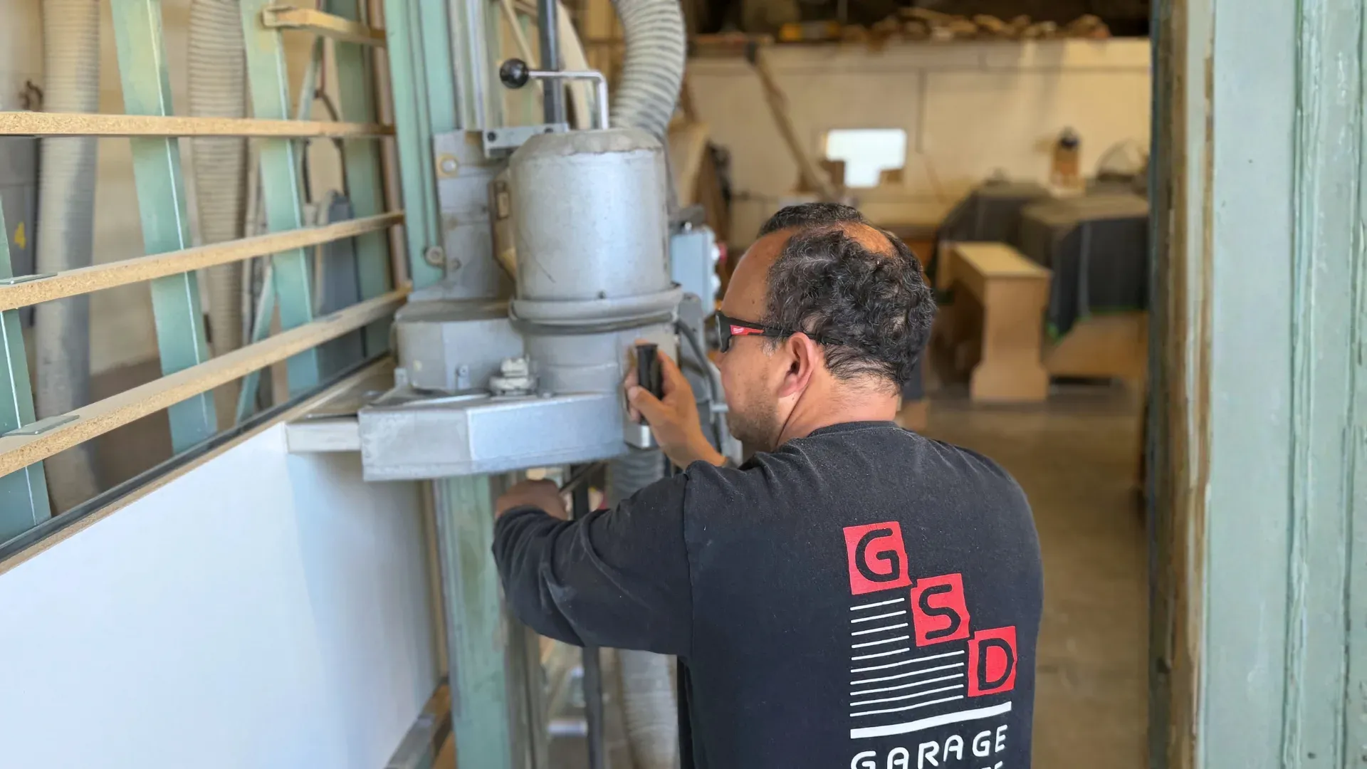 A cabinetmaker working at a machine in the Garage Storage Designs shop.