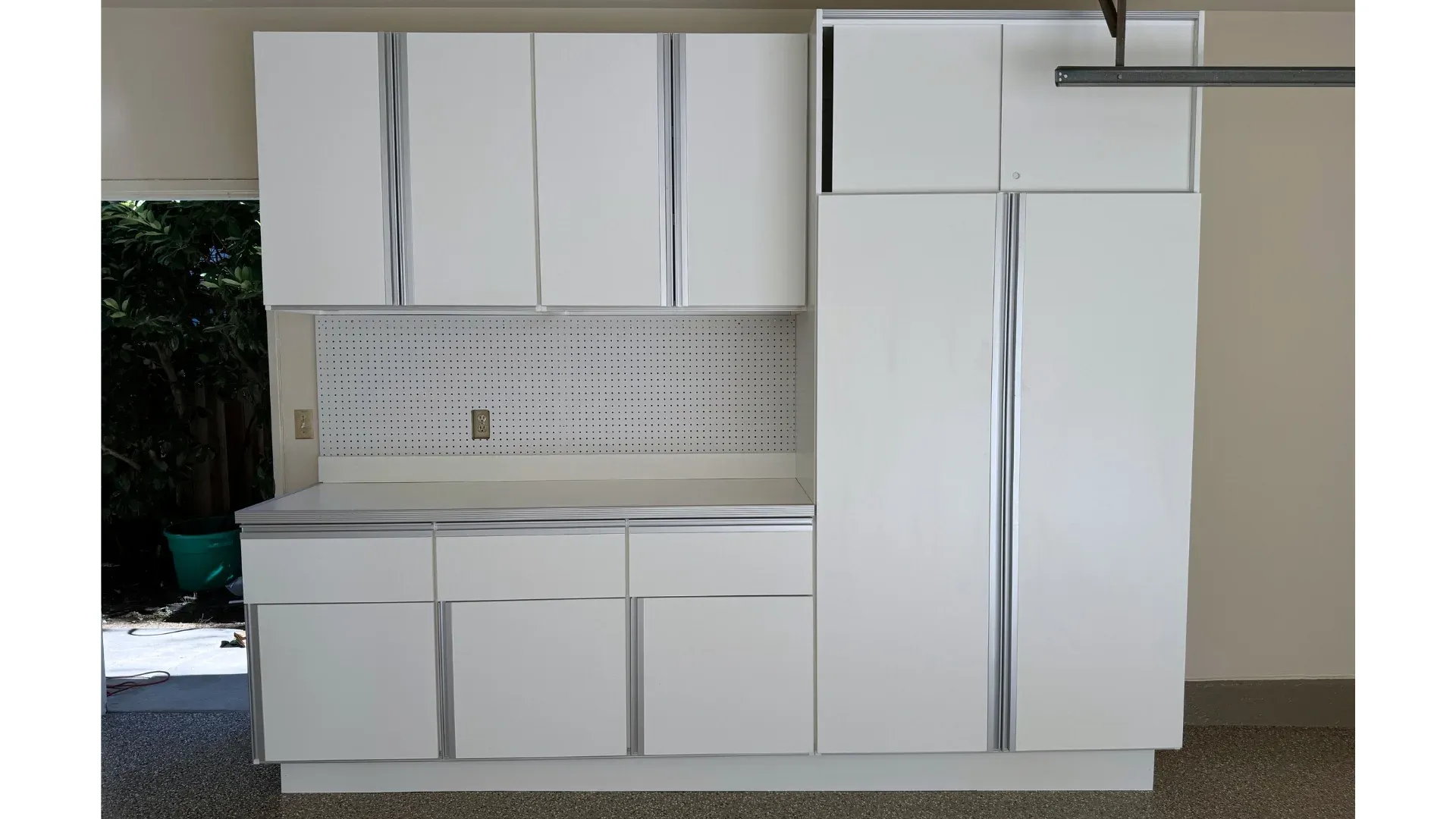 A garage workbench built into a cabinet run, with drawers below the worktop.